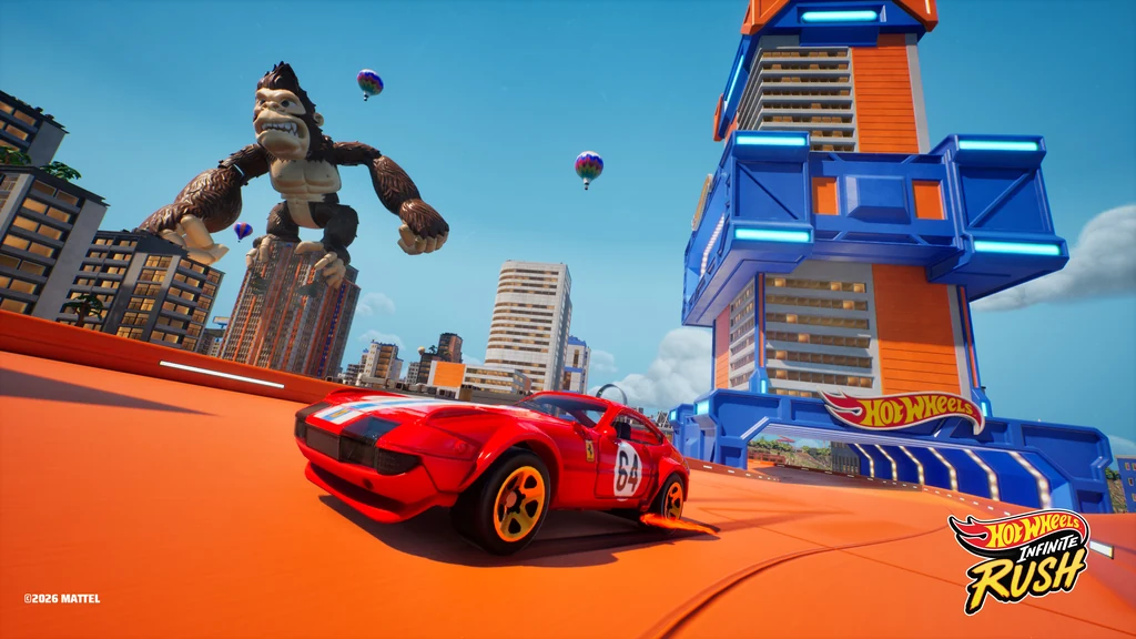 Rotes Hot-Wheels-Auto auf einer orangefarbenen Bahn zwischen Hochhäusern und einer großen Roboterfigur